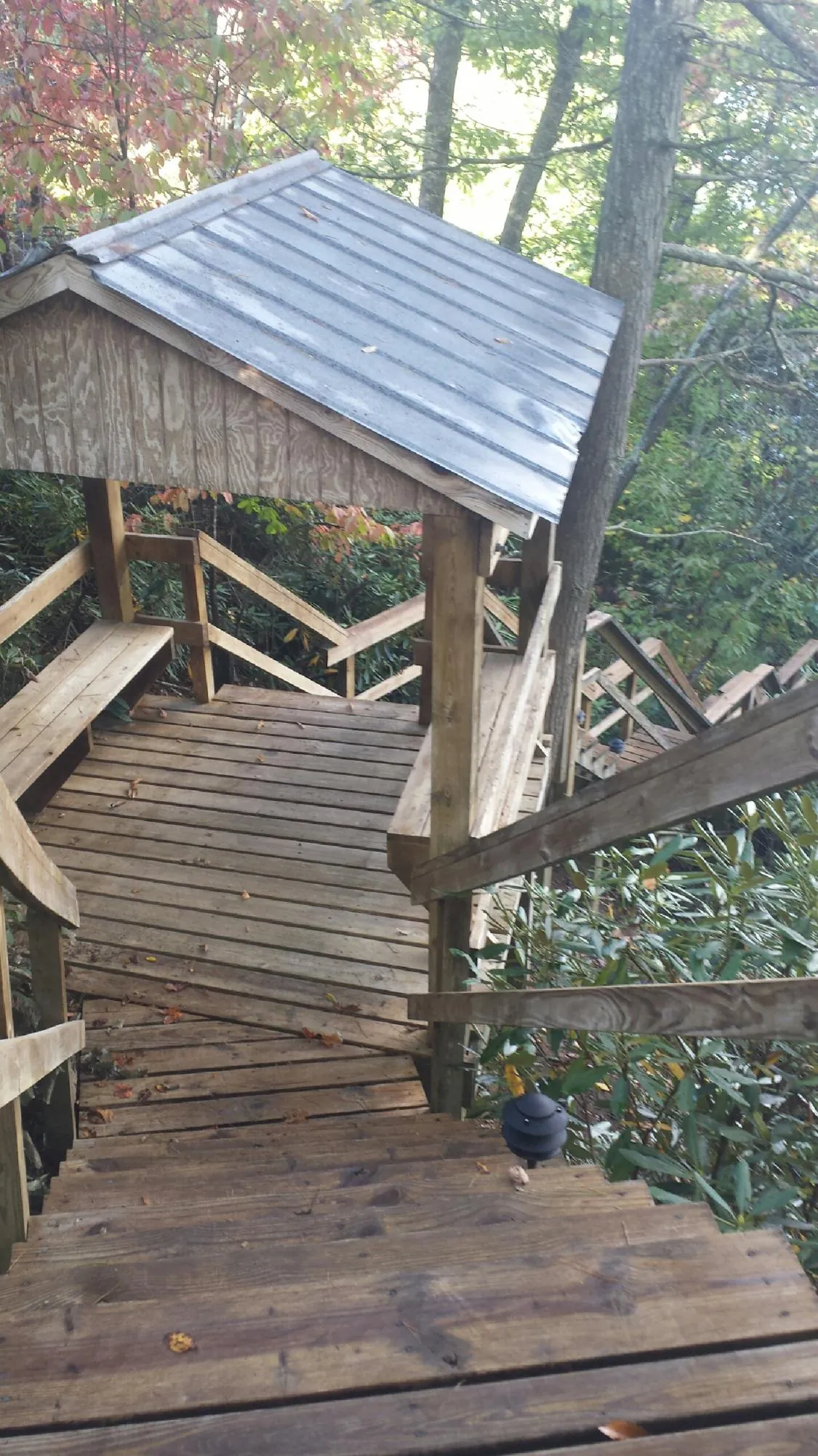 Metal roofed shelter over wooden steps on a wooded walkway — Skylight Repair & Installation work by our crew in Stafford Springs
