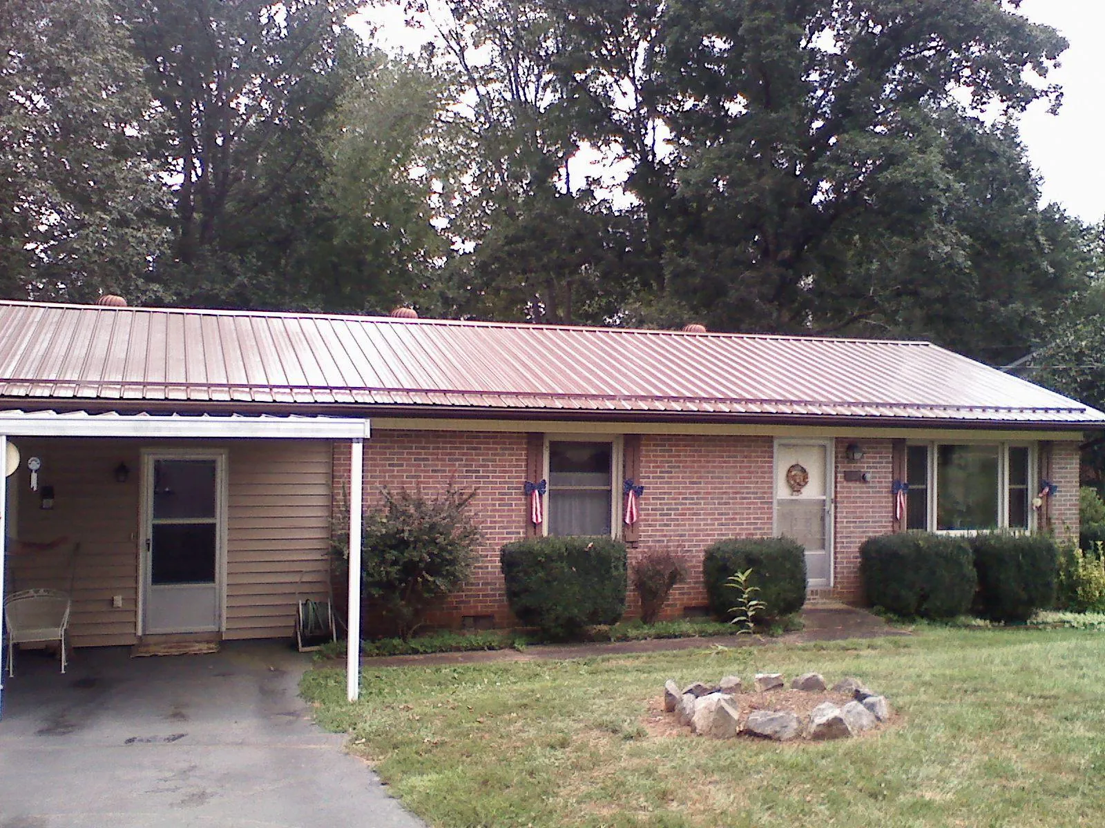 Bronze metal roof and carport on a brick ranch home — Roof Repair work by our crew in Stafford Springs